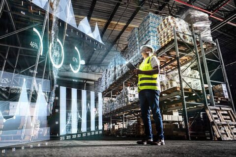 Employee analyzing virtual data with augmented reality interface in a warehouse
